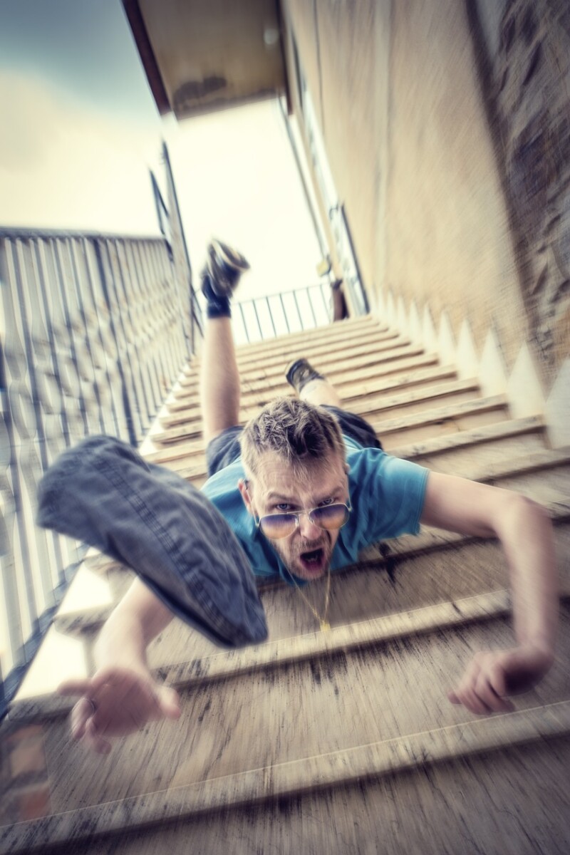 A young male-presenting person falling down the staircase.